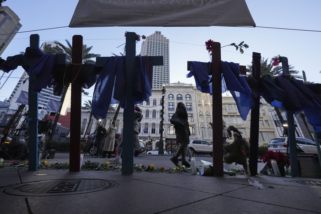 People walk past a memorial on Canal Street 