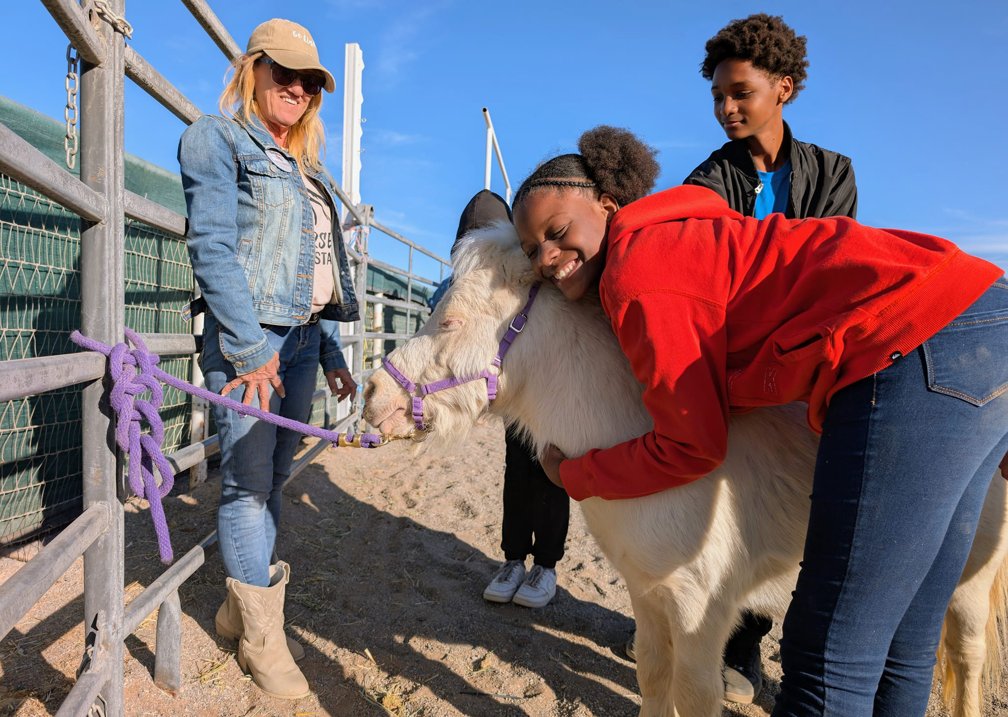 Two teens, pony and volunteer and arena