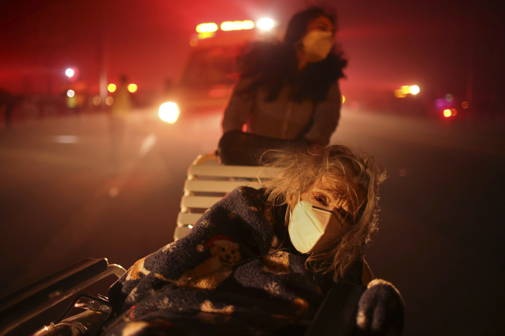 A resident of a senior center is evacuated as the Eaton Fire approaches Altadena, Calif. 