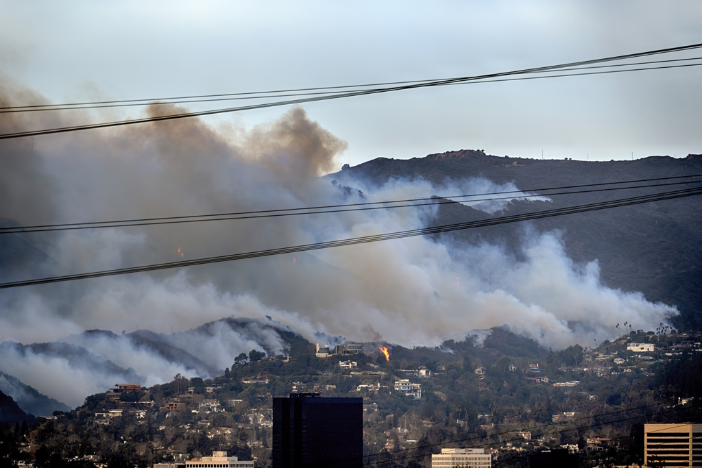 Spot fires along a hillside burn the Brentwood section of Los Angeles