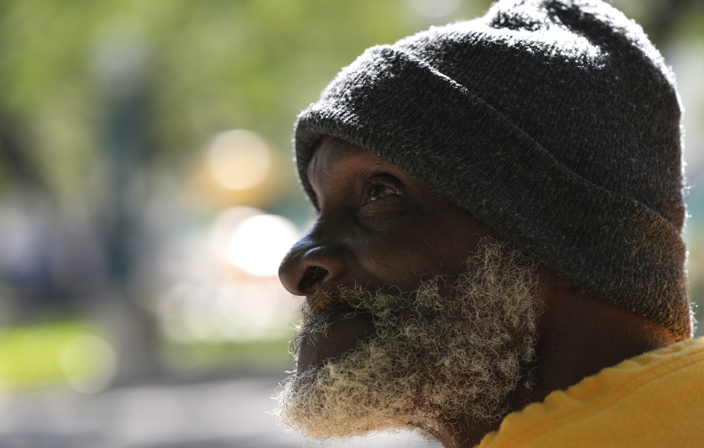 Willie Barnes, 63, who is homeless, talks with a homeless outreach advocate offering shelter as temperatures are forecast to be in the forties this evening in Miami.