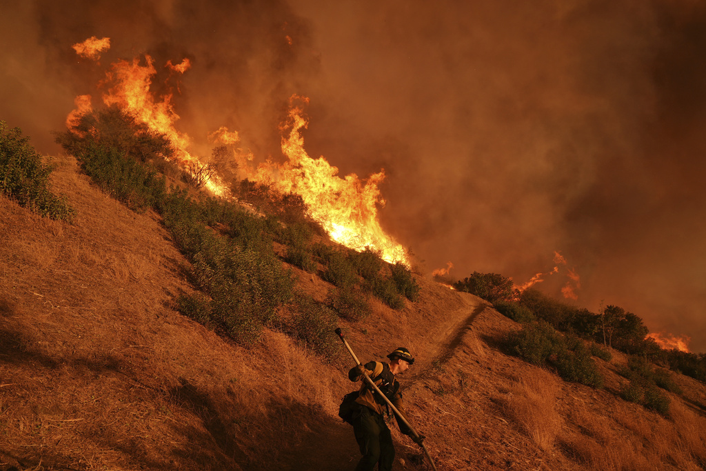 Firefighter battles the Palisades Fire in Mandeville Canyon