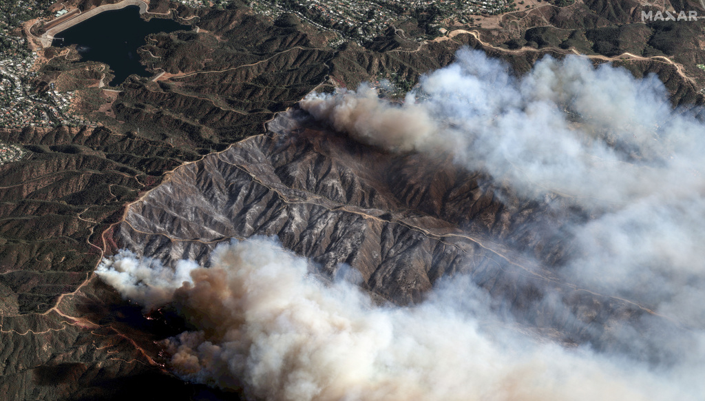 The Palisades Fire burns south of the Encino Reservoir, upper left, in Los Angeles