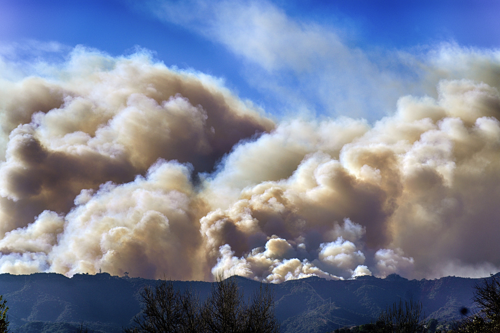 Smoke from the Palisades Fire rises over a ridge as seen from the Encino section of Los Angeles 