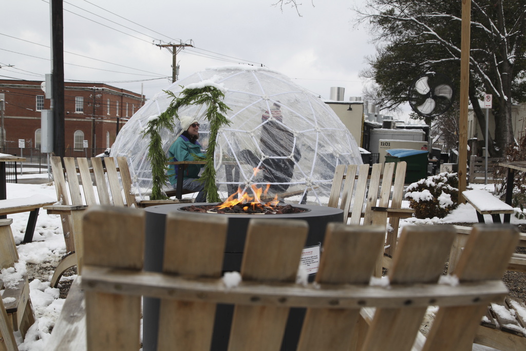  People drink coffee outside of Surefire Coffee Co. after snow fell in the area in Nashville, Tenn. 