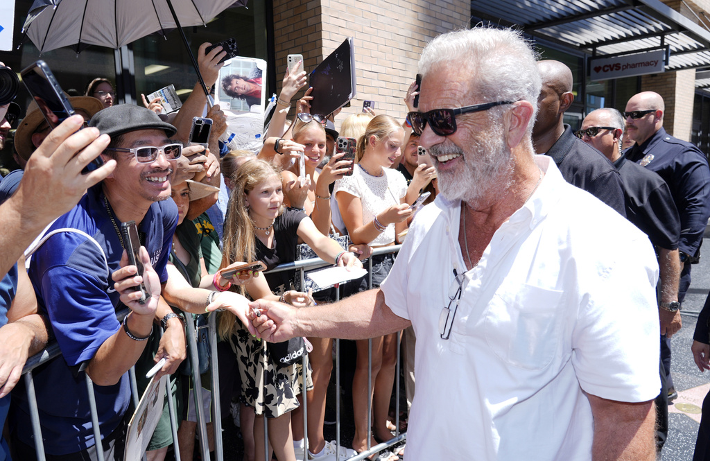 Mel Gibson, right, interacts with crowd members as he leaves a Hollywood Walk of Fame star ceremony for actor Vince Vaughn