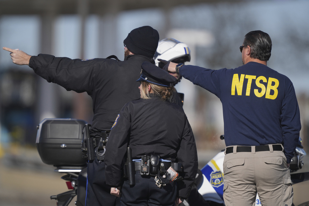 A member of the NTSB talks to Philadelphia Police officers near the scene