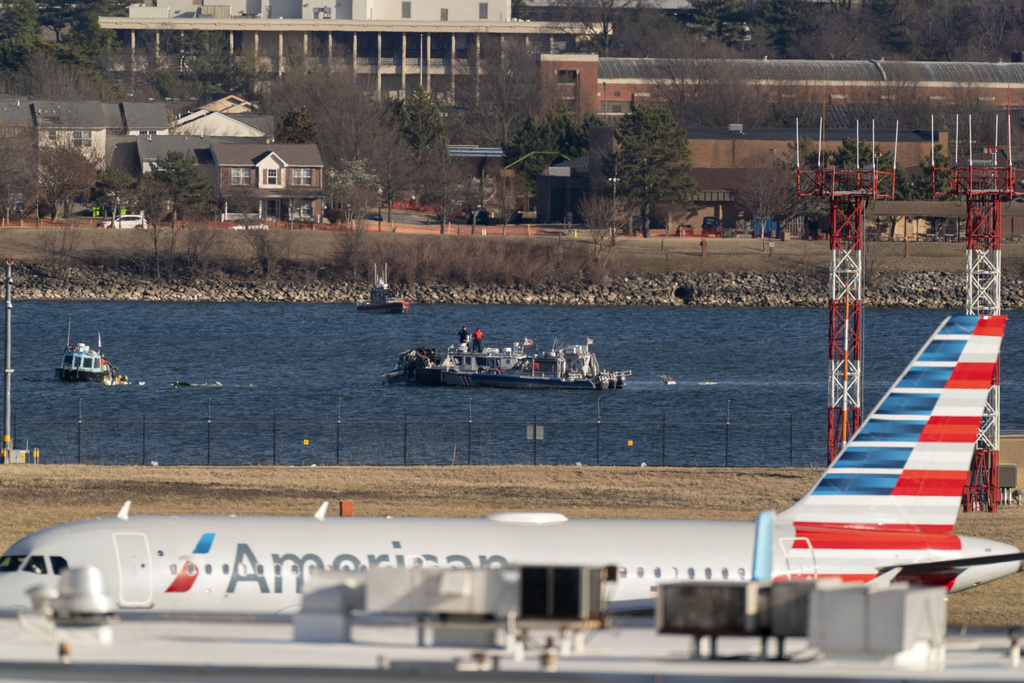 Police and coast guard boats are seen around the wreckage site in the Potomac River