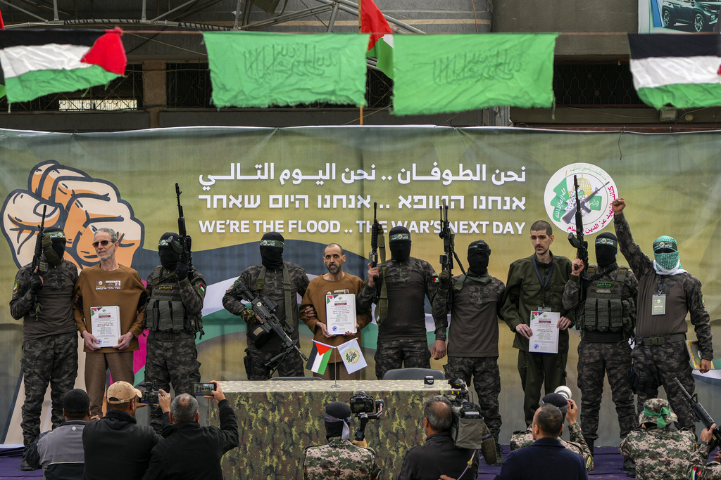 Israeli captives, from left to the right, Ohad Ben Ami, Eli Sharabi and Or Levy, who have been held hostage by Hamas in Gaza since Oct. 7, 2023, are escorted by Hamas fighters 