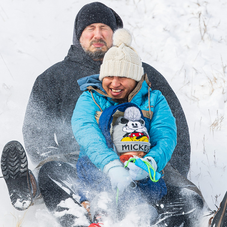Rodney Meester, top, tries to steer his wife Marysol, and son Orlando, 4, down the Holmes Lake hill as a winter storm hits Lincoln, Neb.