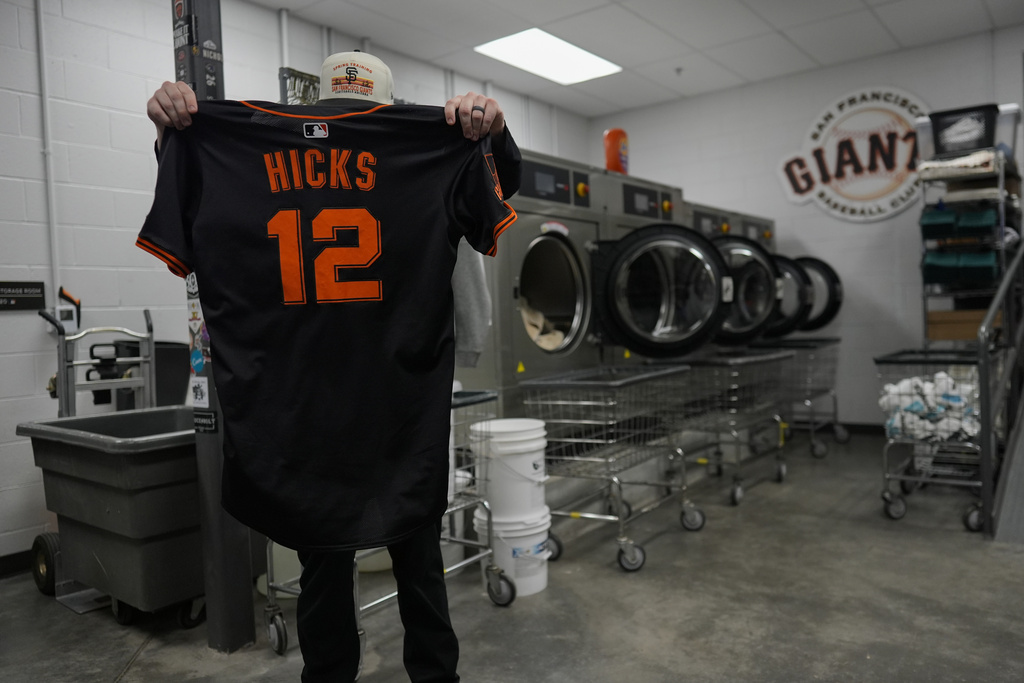 San Francisco Giants clubhouse attendant Riley Halpin inspects pitcher Jordan Hicks