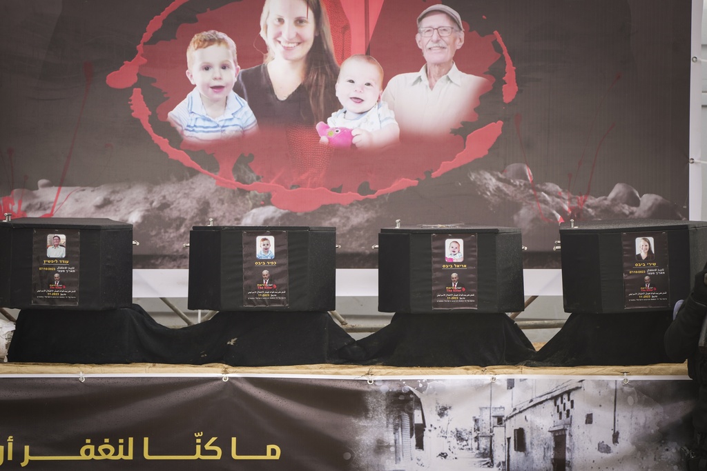 Coffins containing the bodies of four people are displayed on a stage in Khan Younis, southern Gaza Strip, before being handed over to the Red Cross by Hamas and Islamic Jihad