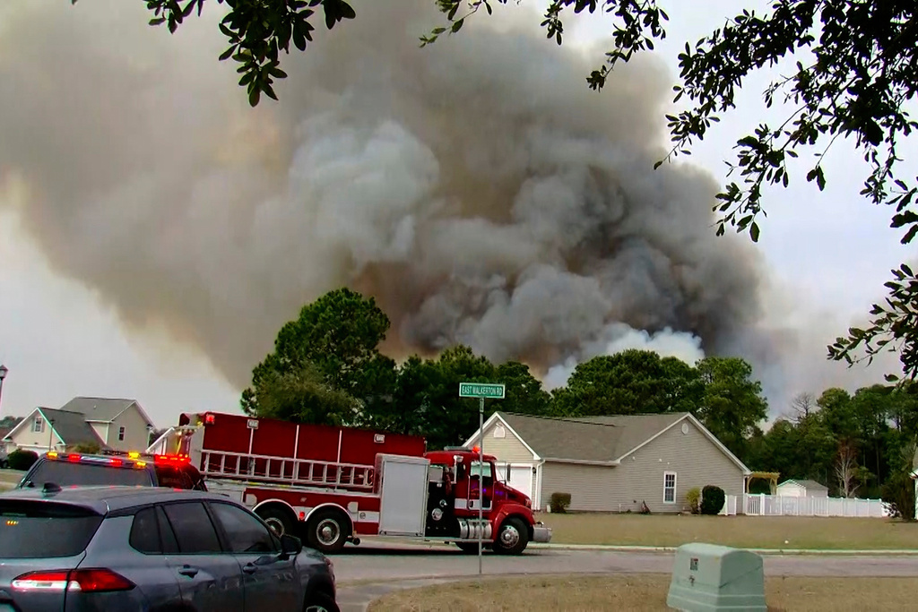 Crews work to contain a fire in the Carolina Forest area west of the coastal resort city of Myrtle Beach, S.C.