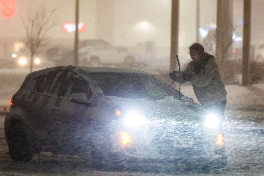 Motorist adjusts their windshield wipers near Saddle Creek Road and Leavenworth Street during a blizzard warning in Omaha