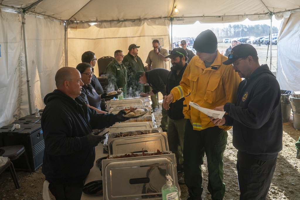 Firefighters from North Carolina and across the U.S. get breakfast after they gather for a morning coordination meeting in Mill Spring, N.C. 