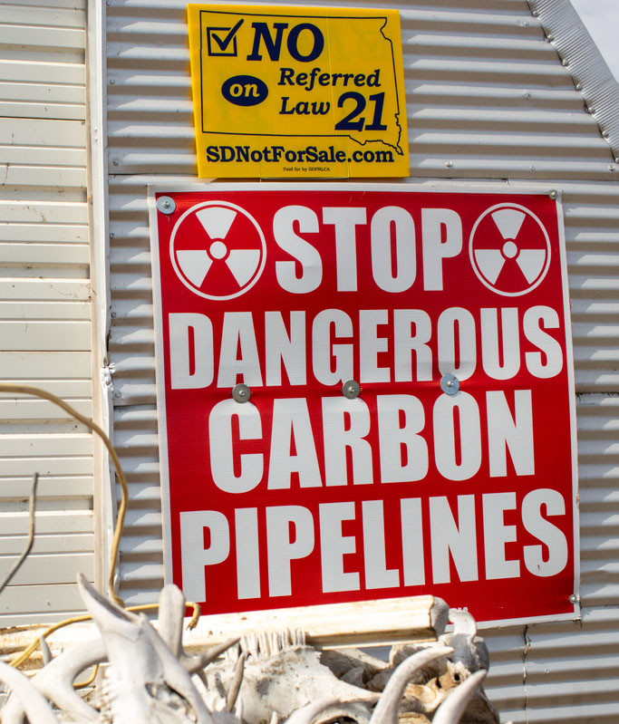  sign protesting carbon pipelines is displayed on a building at Jared Bossly