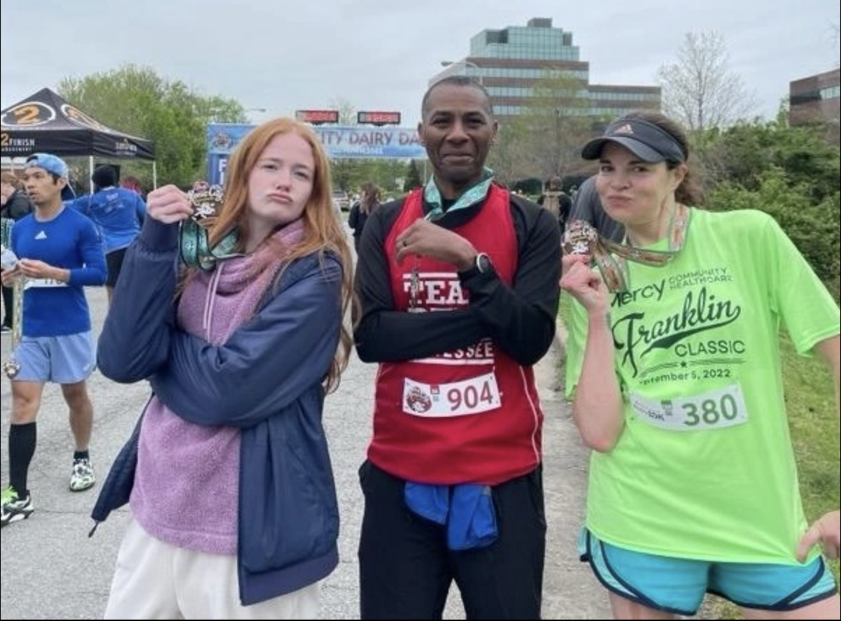 Man and two women holding medals