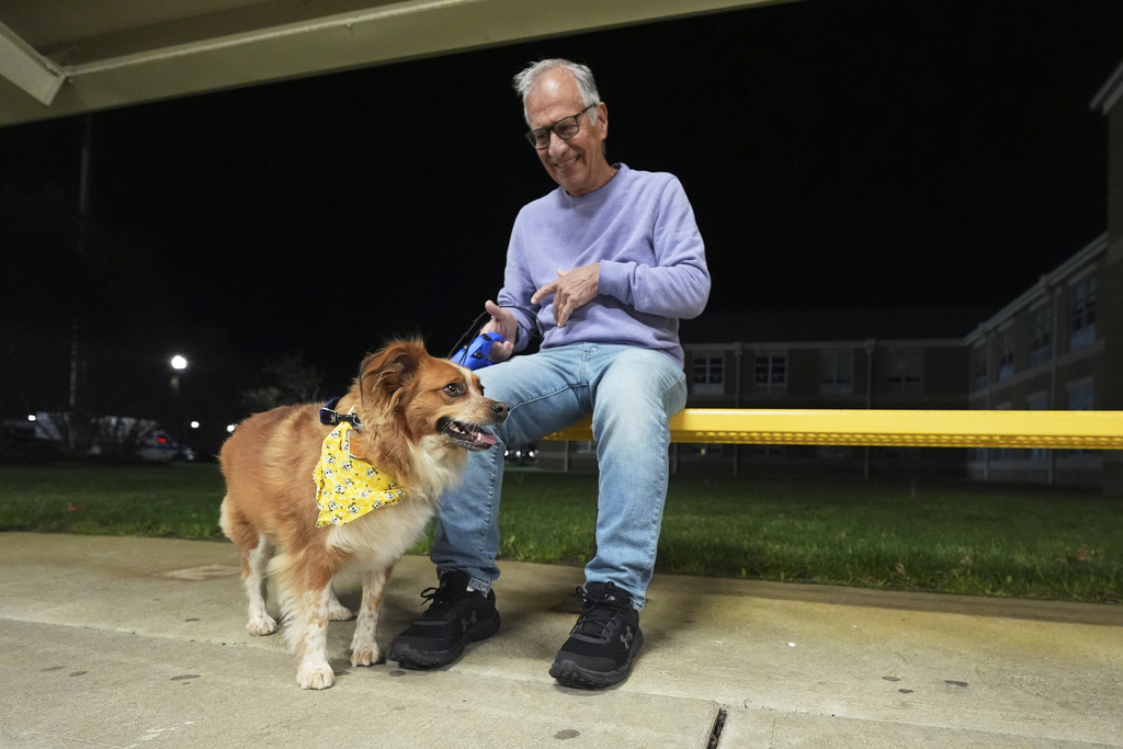 Carmine, of Waretown, and his dog Amber sit outside an evacuation center at Southern Regional High School during wildfires on Tuesday, April 22, 2025, near Stafford Township, N.J.