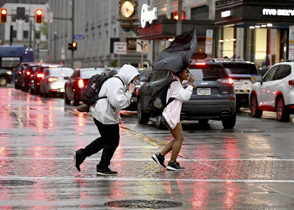 Pedestrians rush across Smithfield St. in the rain in Downtown Pittsburgh