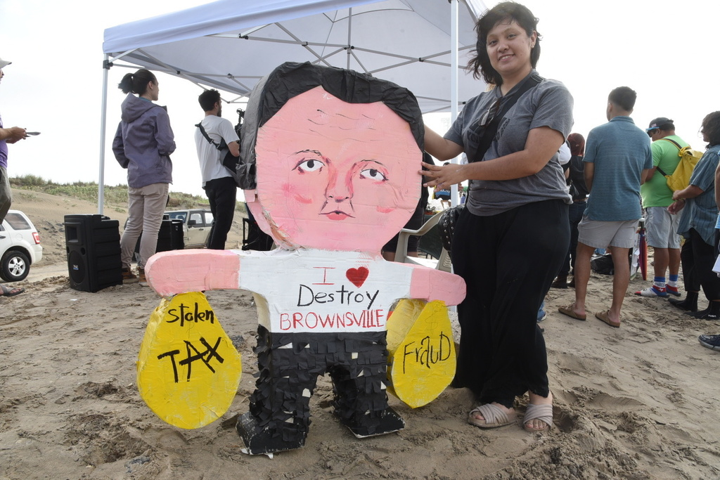 Natalia Salinas holds a piñata of Elon Musk during a protest at Boca Chica beach, Texas