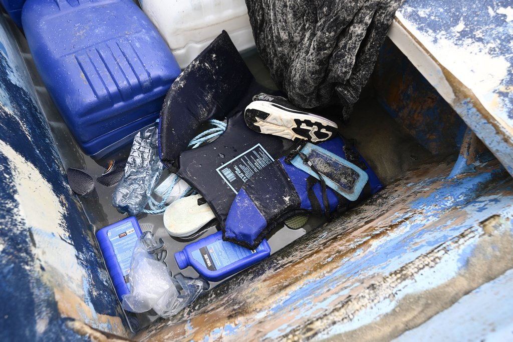 Life jackets and personal items are seen in a boat that capsized at Torrey Pines State beach in San Diego