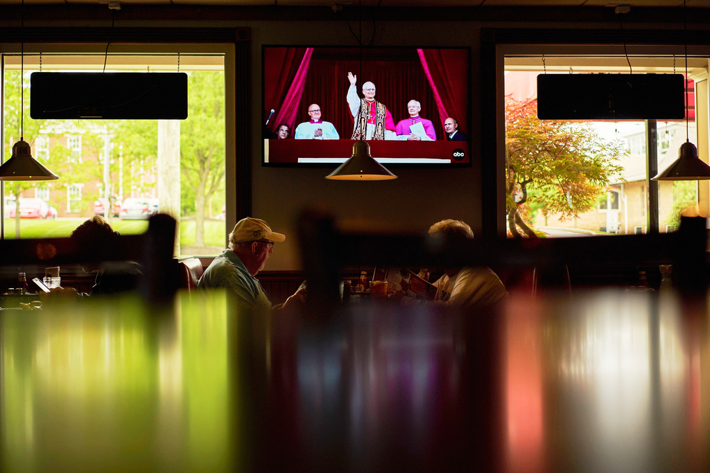 Patrons watch live coverage of the newly elected Pope Leo XIV from St. Peter