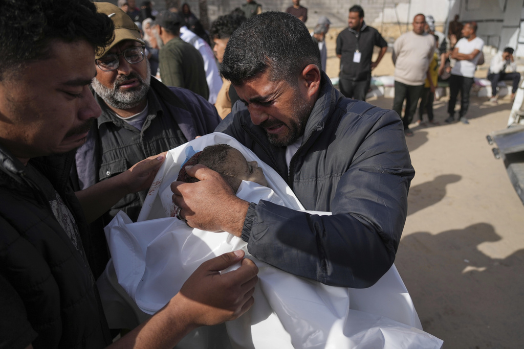Mohannad Al-Agha, holds body of his niece Zeina Al- Agha, 2, killed in an overnight Israeli airstrike, during her funeral at Nasser Hospital in Khan Younis, Gaza Strip