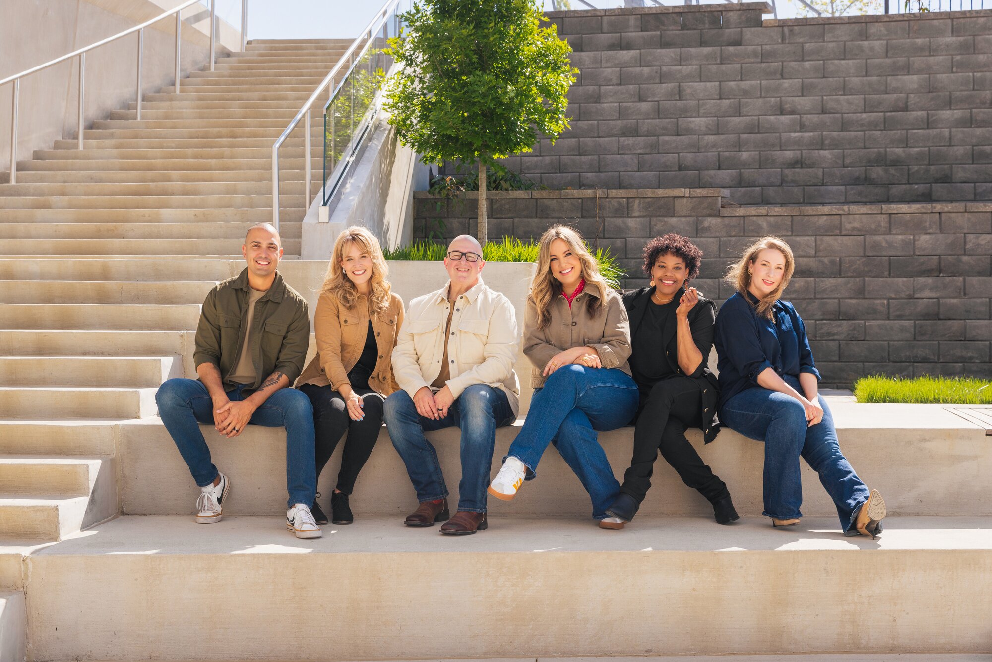 The KLOVE DJs sitting outside the KLOVE building in lineup order